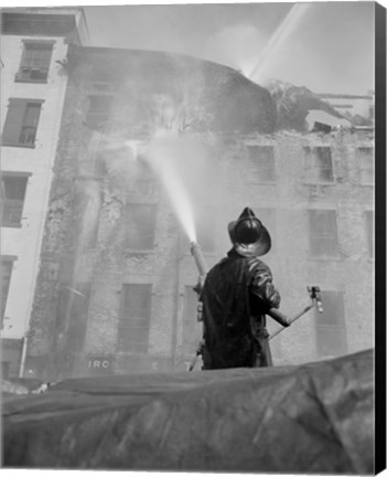 Framed Firefighter pouring water on burning building, low angle view Print