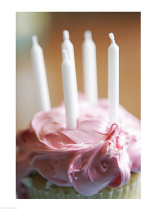Framed Close-up of a pink frosted cupcake with white unlit candles Print