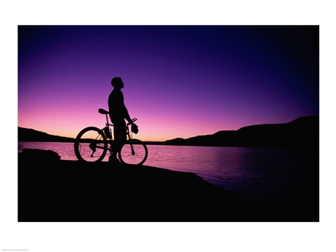 Framed purple Silhouette of a man standing with mountain bike, Lake Powell, Utah Print