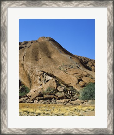 Framed Tourists climbing on a rock, Ayers Rock, Uluru-Kata Tjuta National Park, Australia Print
