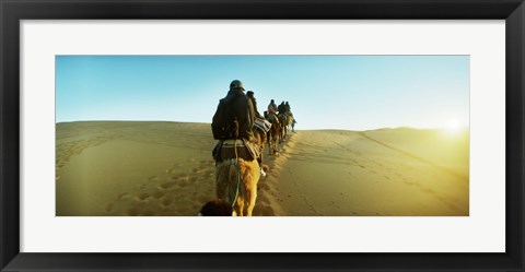 Framed Row of people riding camels through the desert, Sahara Desert, Morocco Print