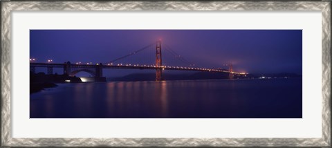 Framed Suspension bridge lit up at dawn viewed from fishing pier, Golden Gate Bridge, San Francisco Bay, San Francisco, California, USA Print