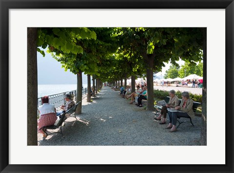 Framed People sitting on benches among trees at lakeshore, Lake Como, Cernobbio, Lombardy, Italy Print