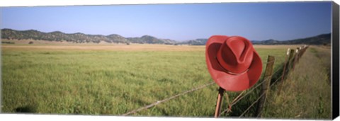 Framed USA, California, Red cowboy hat hanging on the fence Print