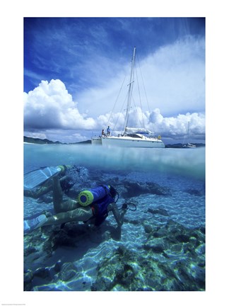 Framed Scuba diver in the water with a sail boat in the background, British Virgin Islands Print