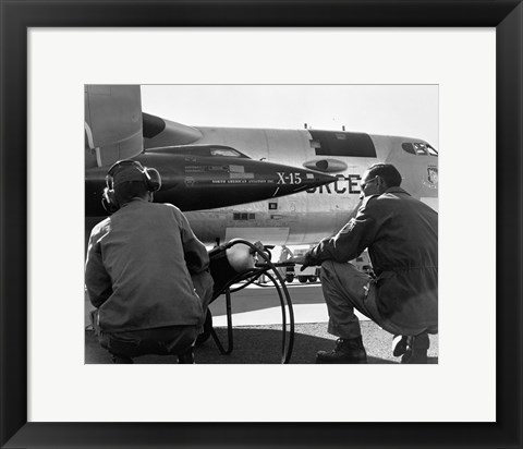 Framed Rear view of two men crouching near fighter planes, X-15 Rocket Research Airplane, B-52 Mothership Print
