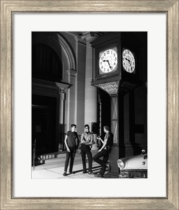 Framed Young men standing below clock at night Print