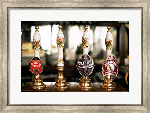 Framed Close-up of beer tap handles in a bar, London, England Print