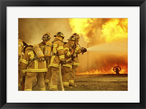 Framed Rear view of a group of firefighters extinguishing a fire Print