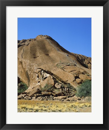 Framed Tourists climbing on a rock, Ayers Rock, Uluru-Kata Tjuta National Park, Australia Print