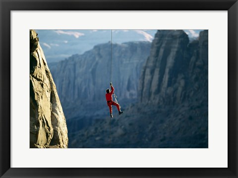 Framed Rear view of a man rappelling down a rock Print