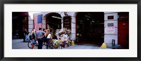 Framed Rear view of three people standing in front of a memorial at a fire station, New York City, New York State, USA Print