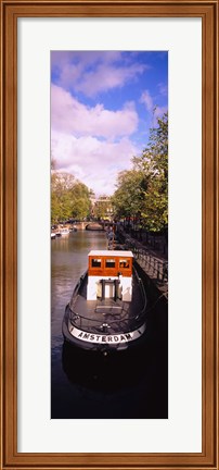 Framed Tourboat docked in a channel, Amsterdam, Netherlands Print