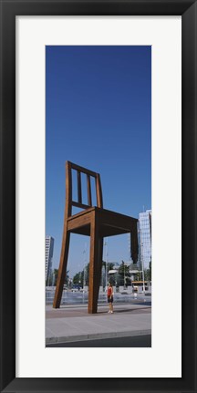 Framed Woman standing under a sculpture of large broken chair, Geneva, Switzerland Print