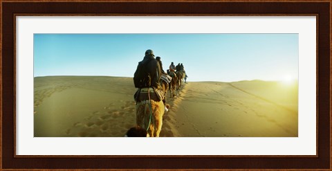 Framed Row of people riding camels through the desert, Sahara Desert, Morocco Print