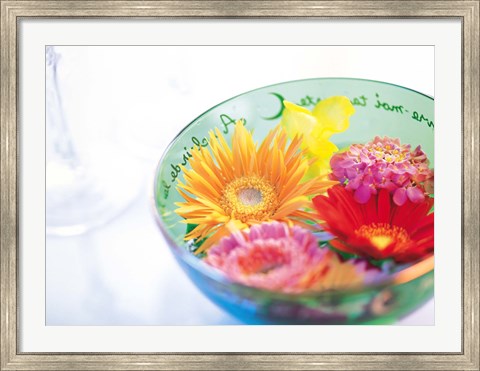 Framed Pink, orange and yellow flowers floating in a blue bowl Print