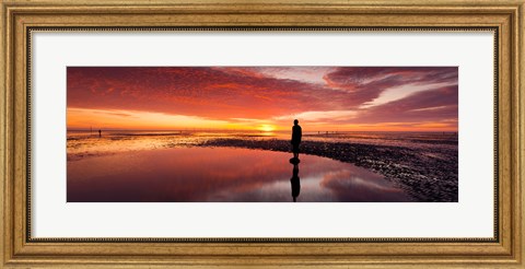Framed Silhouette of human sculpture on the beach at sunset, Another Place, Crosby Beach, Merseyside, England Print