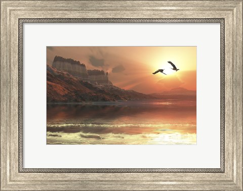 Framed Two Bald Eagles fly along a mountainous coastline at sunset Print
