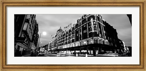 Framed Low angle view of buildings lit up at night, Harrods, London, England BW Print