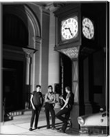 Framed Young men standing below clock at night