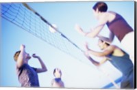 Framed Low angle view of two young couples playing beach volleyball