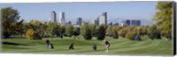Framed Four people playing golf with buildings in the background, Denver, Colorado, USA