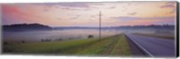 Framed Country road and telephone lines splitting farmlands at dawn, Finland