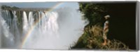 Framed Woman looking at a rainbow over the Victoria Falls, Zimbabwe