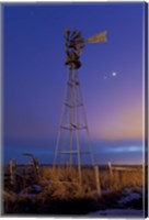 Framed Venus and Jupiter are visible behind an old farm water pump windmill, Alberta, Canada