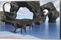 Framed Diplodocus dinosaurs wade through shallow waters of a beautiful seashore