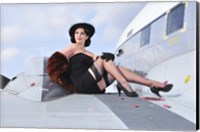 Framed Glamorous woman in 1940's style attire sitting on a vintage aircraft