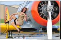 Framed 1940's style pin-up girl posing on a T-6 aircraft