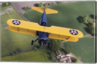 Framed Boeing Stearman Model 75 Kaydet flying over fields