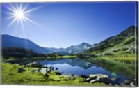 Framed Muratov Lake against blue sky and bright sun in Pirin National Park, Bulgaria