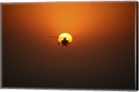 Framed AH-64D Apache Helicopter Flying into the Sun over Iraq