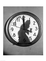 Framed Close-up of the shadow of a person carrying a scythe on a clock