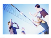 Framed Low angle view of two young couples playing beach volleyball