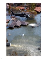 Framed Blackhawk helicopter drops sandbags into an area where the levee broke due to Hurricane Katrina