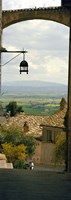 Framed Umbrian countryside viewed through an alleyway, Assisi, Perugia Province, Umbria, Italy