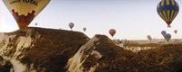 Framed Hot air balloons soaring over a mountain ridge, Cappadocia, Central Anatolia Region, Turkey
