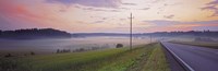 Framed Country road and telephone lines splitting farmlands at dawn, Finland