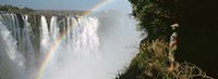 Framed Woman looking at a rainbow over the Victoria Falls, Zimbabwe