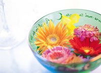 Framed Pink, orange and yellow flowers floating in a blue bowl