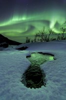 Framed Aurora Borealis over a frozen river, Norway