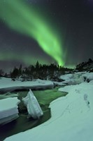 Framed Aurora Borealis over a frozen Tennevik River, Troms, Norway
