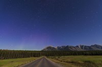 Framed Northern autumn constellations rising over a road in Banff National Park, Canada