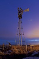 Framed Venus and Jupiter are visible behind an old farm water pump windmill, Alberta, Canada