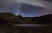 Framed Star trails and the blurred band of the Milky Way above a lake in the Eastern Sierra Nevada