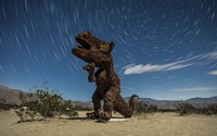 Framed Tyrannosaurus rex sculpture against a backdrop of star trails, California