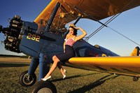 Framed 1940's style pin-up girl sitting on the wing of a Stearman biplane